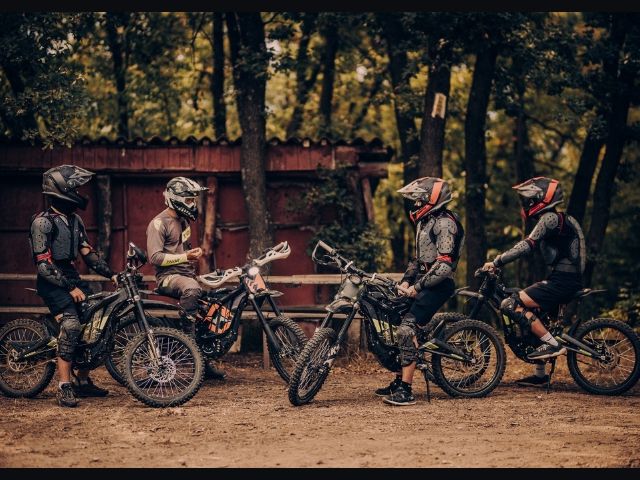 четирима мотористи се наслаждават на гледка в гората - снимка